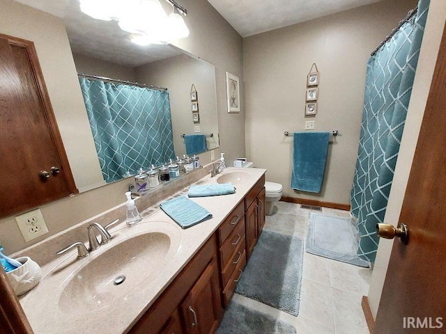 bathroom featuring toilet, tile patterned flooring, and vanity