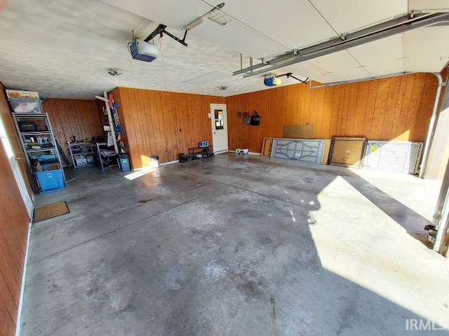 garage featuring a garage door opener and wooden walls