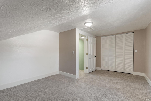 additional living space with lofted ceiling, light colored carpet, and a textured ceiling