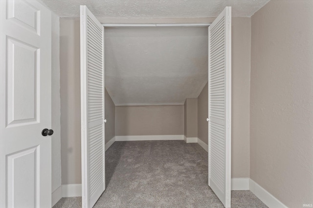 walk in closet featuring carpet floors and lofted ceiling