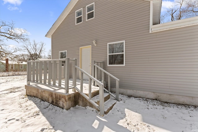 view of snow covered back of property