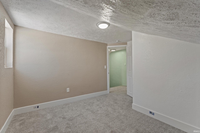 carpeted empty room with a textured ceiling