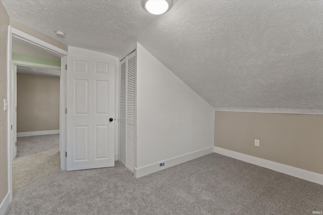 bonus room featuring a textured ceiling, light carpet, and vaulted ceiling