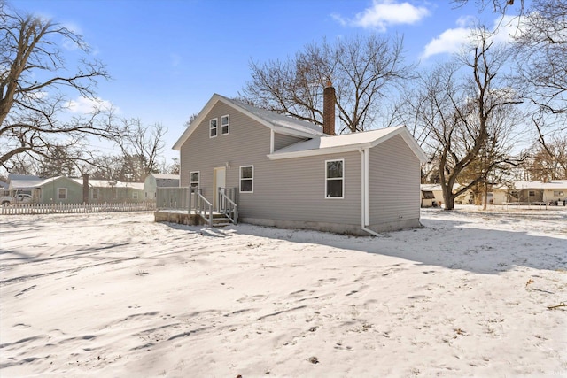 view of snow covered back of property