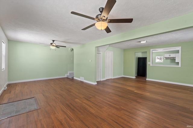 unfurnished living room with ceiling fan, a textured ceiling, and dark hardwood / wood-style flooring