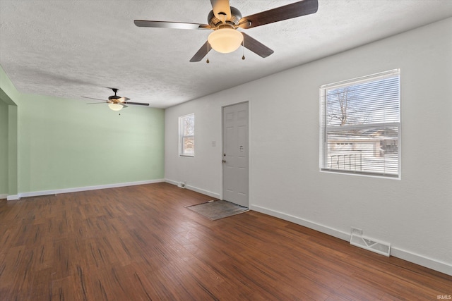 entrance foyer with ceiling fan, a textured ceiling, and dark hardwood / wood-style flooring