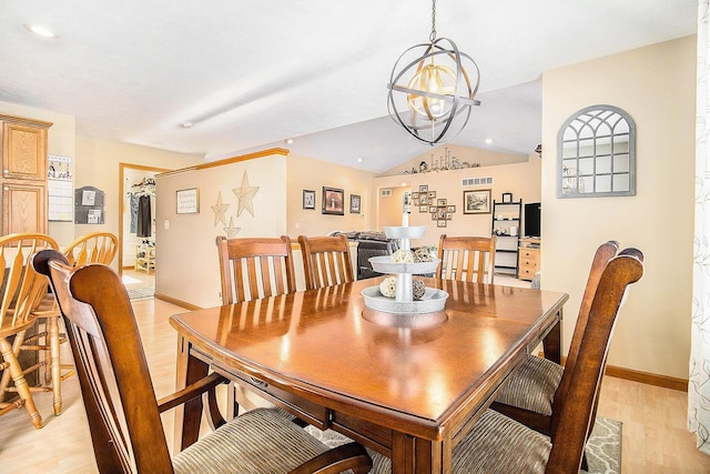 dining area with a notable chandelier and light hardwood / wood-style floors