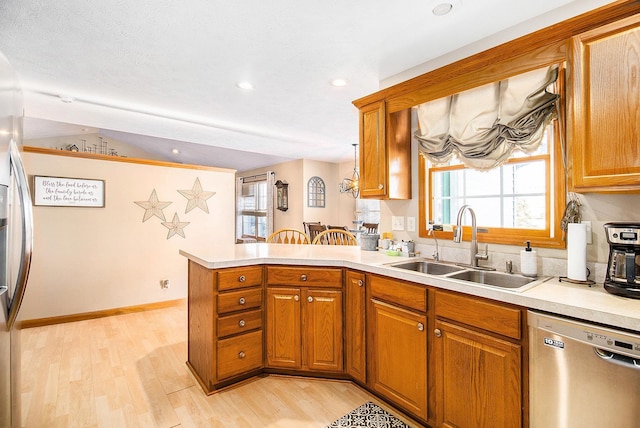 kitchen featuring light hardwood / wood-style flooring, sink, stainless steel dishwasher, and kitchen peninsula