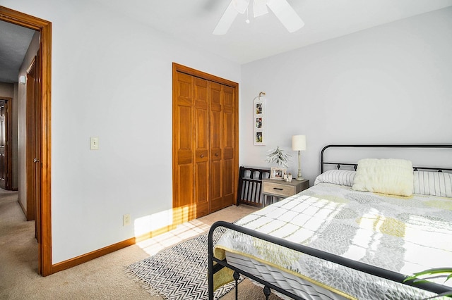 carpeted bedroom featuring ceiling fan and a closet