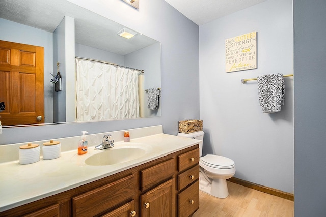 bathroom with hardwood / wood-style flooring, vanity, and toilet