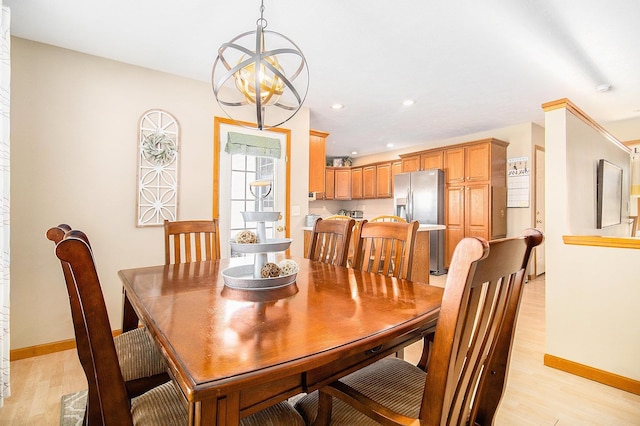 dining room with an inviting chandelier and light hardwood / wood-style flooring