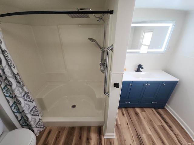 bathroom with vanity, wood-type flooring, toilet, and walk in shower