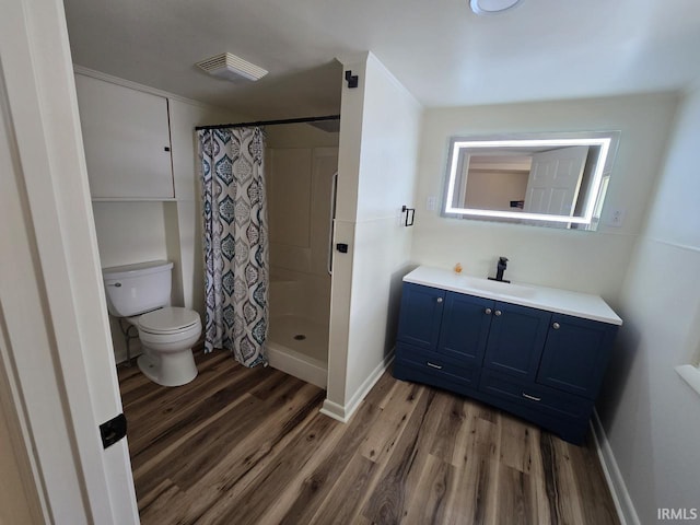 bathroom with vanity, hardwood / wood-style flooring, curtained shower, and toilet