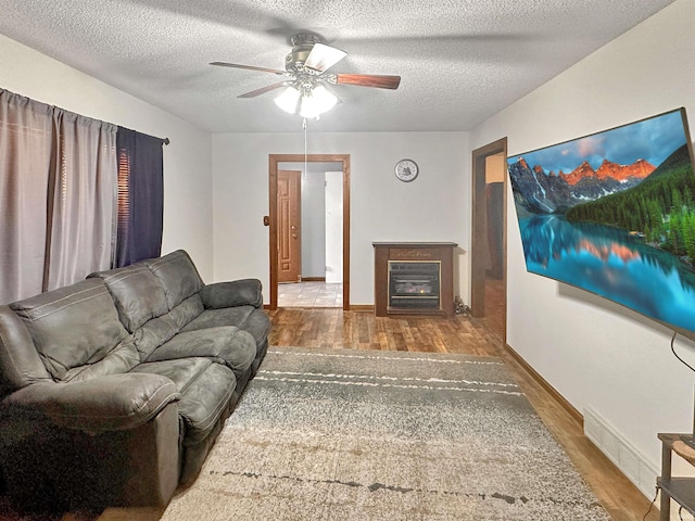 living room featuring a textured ceiling, ceiling fan, and hardwood / wood-style floors