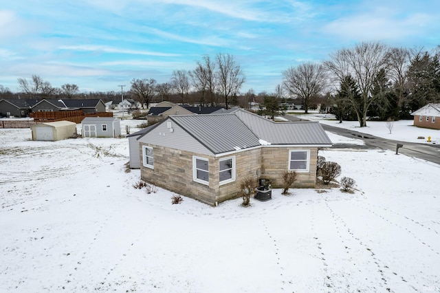 snow covered rear of property featuring cooling unit