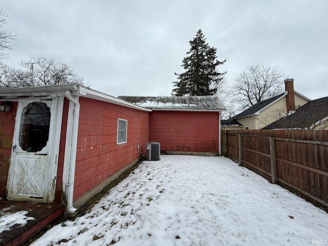 yard layered in snow featuring central AC unit