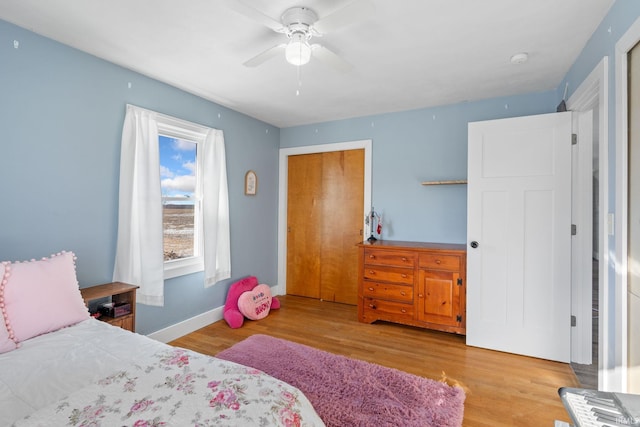 bedroom featuring ceiling fan, a closet, and light hardwood / wood-style floors