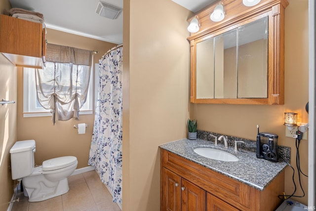 bathroom featuring toilet, vanity, tile patterned flooring, and walk in shower