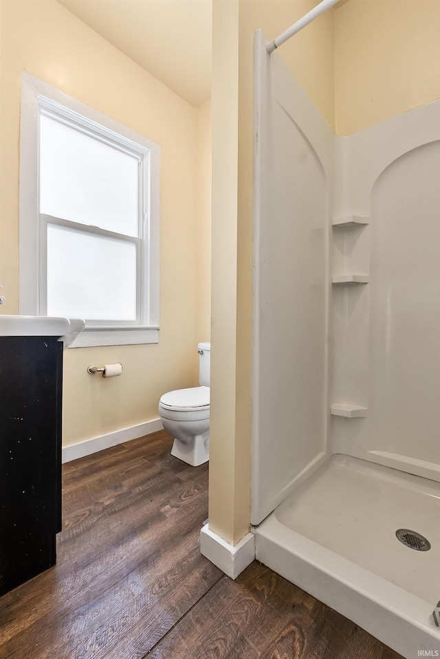 bathroom with toilet, wood-type flooring, and walk in shower