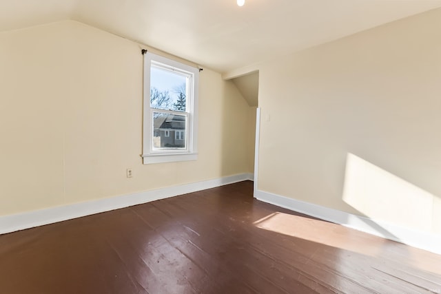 bonus room with dark wood-type flooring and lofted ceiling