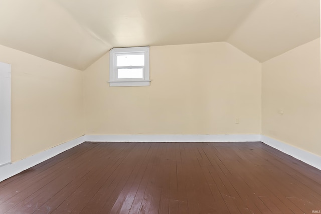 additional living space featuring vaulted ceiling and hardwood / wood-style flooring