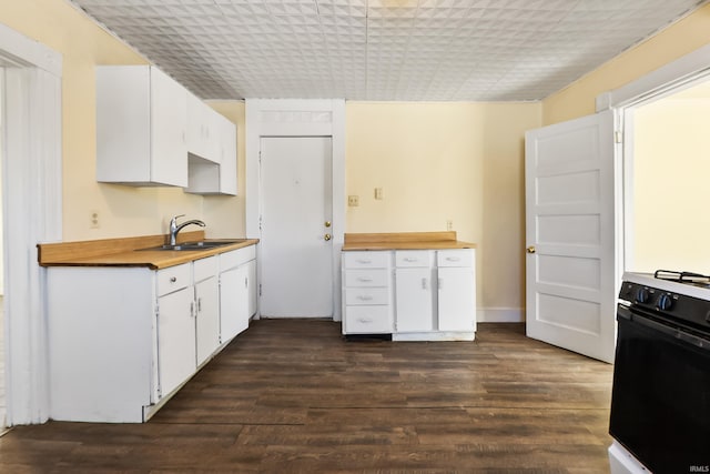 kitchen with dark wood-type flooring, sink, white cabinetry, and range with gas stovetop