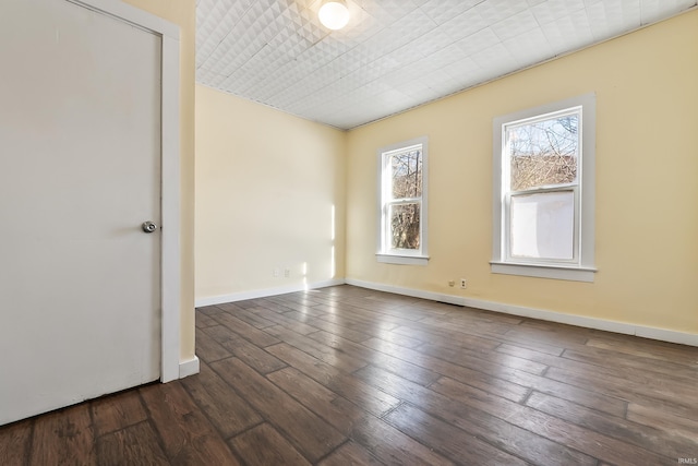 empty room with dark hardwood / wood-style flooring