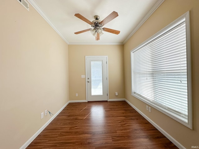 doorway featuring dark wood-type flooring, a wealth of natural light, crown molding, and ceiling fan