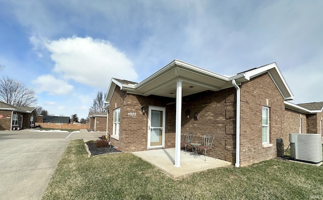 view of home's exterior featuring a patio area, central AC unit, and a lawn