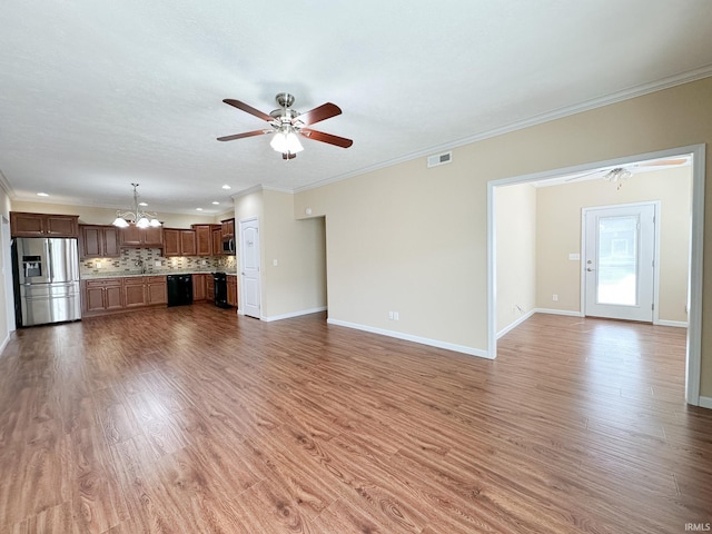 unfurnished living room with wood-type flooring, ceiling fan with notable chandelier, and crown molding