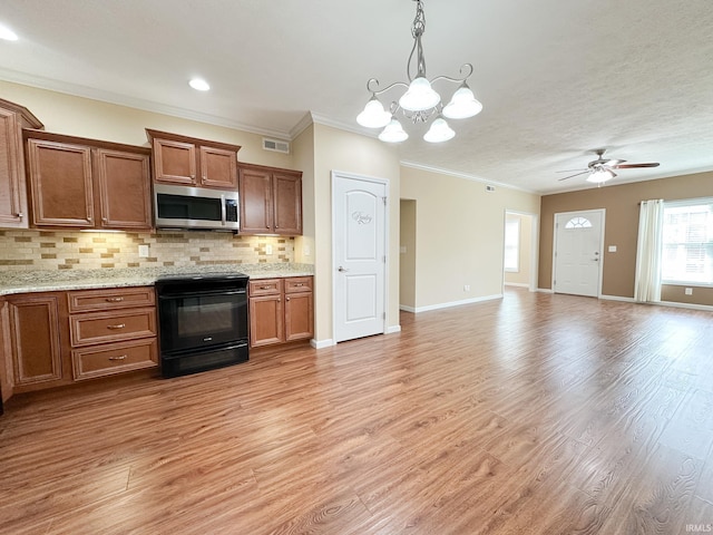 kitchen with tasteful backsplash, light wood-type flooring, pendant lighting, crown molding, and black / electric stove