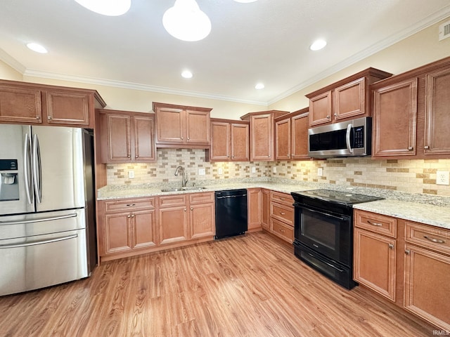 kitchen with sink, light hardwood / wood-style floors, tasteful backsplash, and black appliances