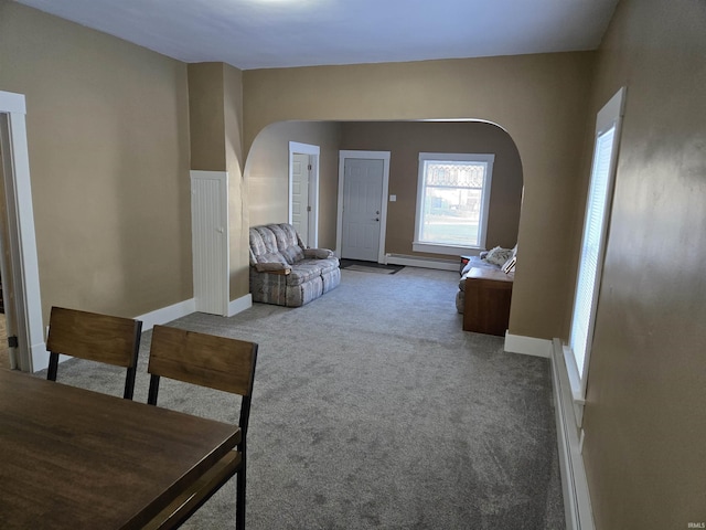 living room with a baseboard heating unit and carpet