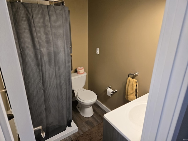 bathroom with toilet, wood-type flooring, and walk in shower