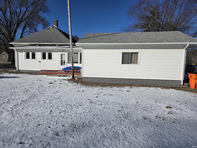 view of snow covered back of property