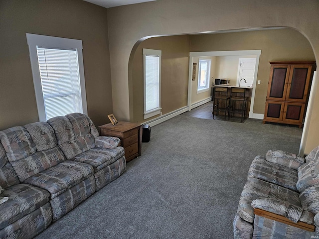 carpeted living room featuring a baseboard heating unit