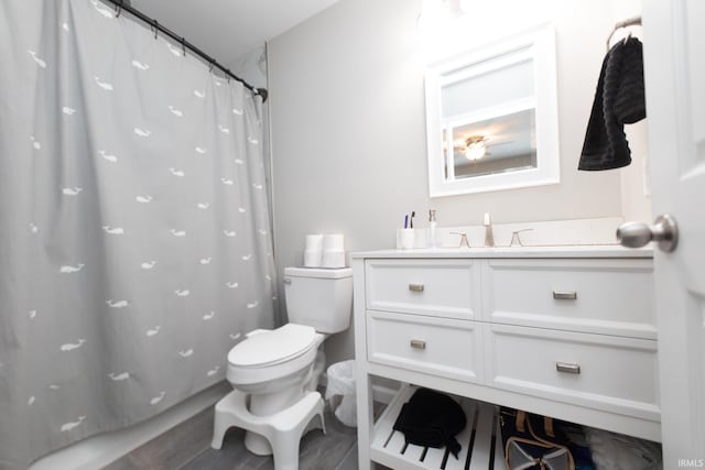 bathroom with toilet, vanity, and a shower with shower curtain