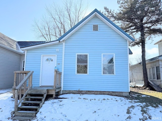 view of snow covered back of property