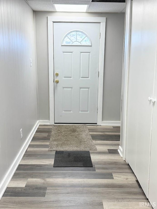 entryway with wood-type flooring and a paneled ceiling