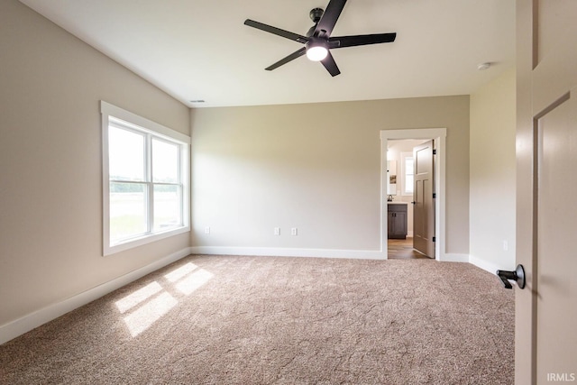 empty room featuring ceiling fan and light colored carpet