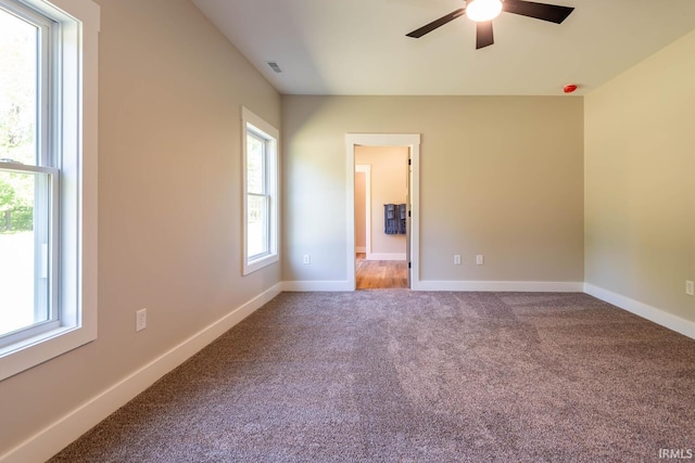 carpeted empty room with ceiling fan and a healthy amount of sunlight