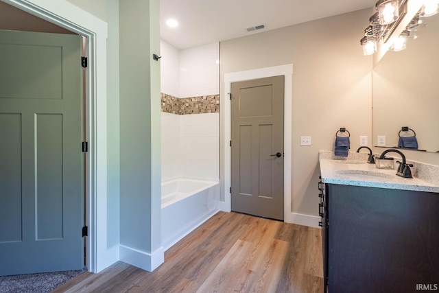 bathroom featuring hardwood / wood-style floors, bathing tub / shower combination, and vanity