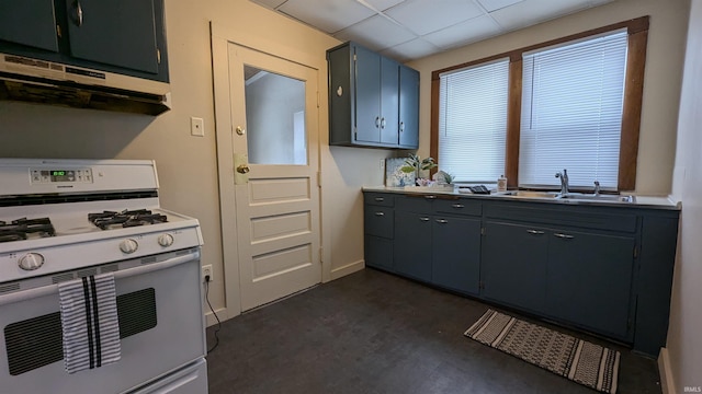 kitchen featuring white gas range, sink, and a drop ceiling