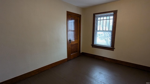 unfurnished room with dark hardwood / wood-style flooring