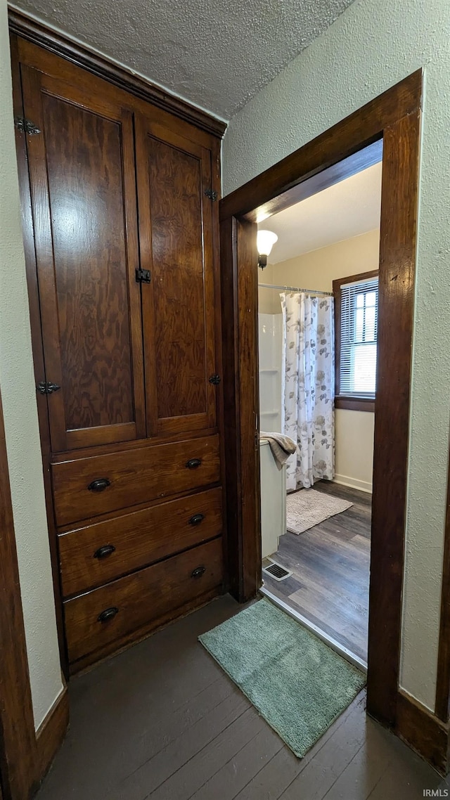 corridor featuring a textured ceiling and light hardwood / wood-style flooring