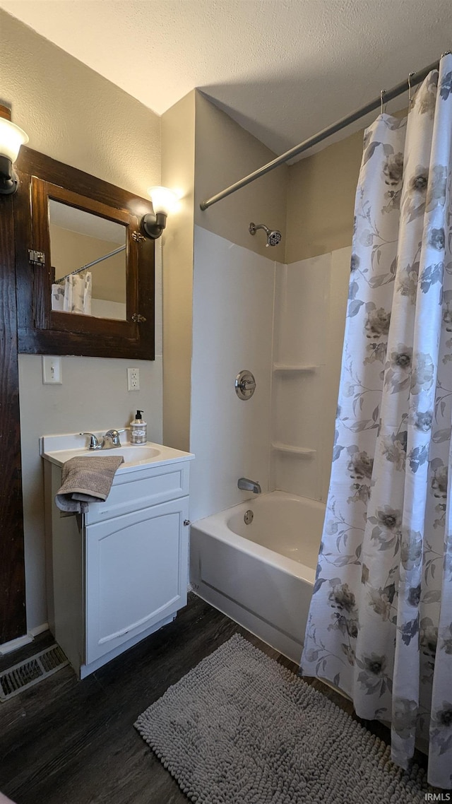 bathroom featuring vanity, a textured ceiling, shower / tub combo with curtain, and wood-type flooring