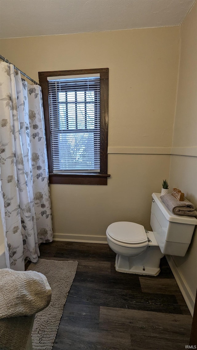 bathroom with toilet, walk in shower, and wood-type flooring