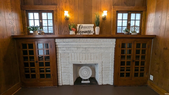 unfurnished living room with a fireplace and wooden walls