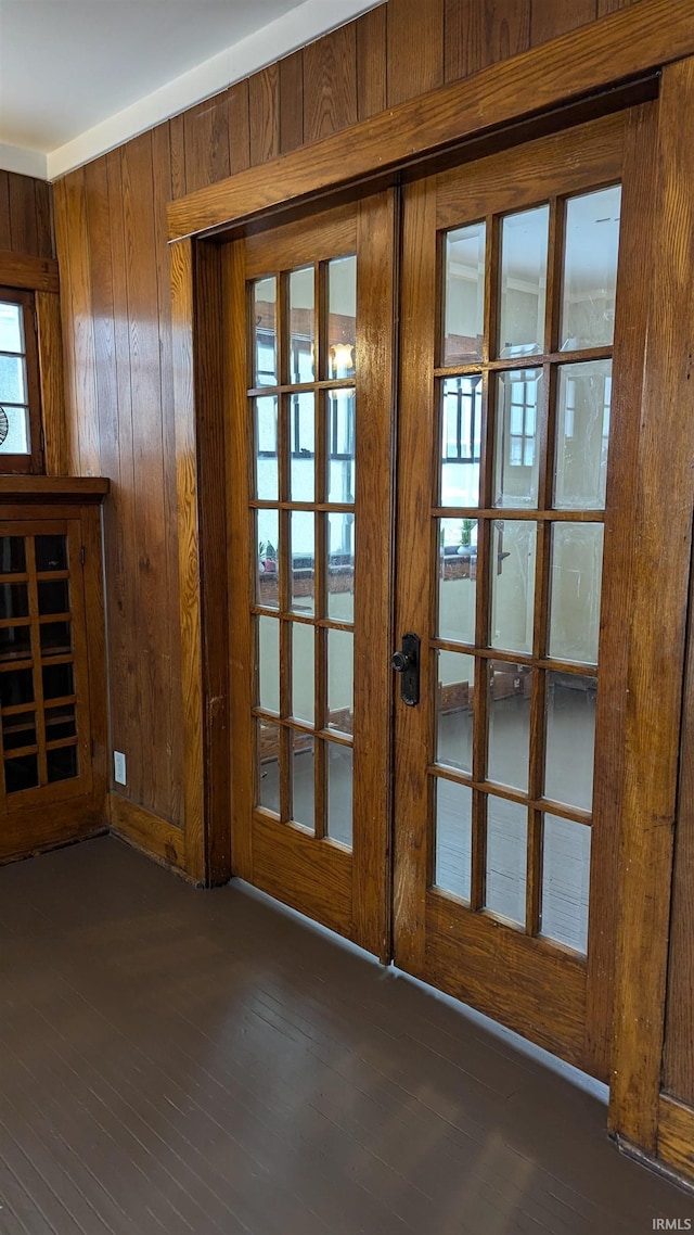 entryway with dark wood-type flooring, french doors, and wooden walls