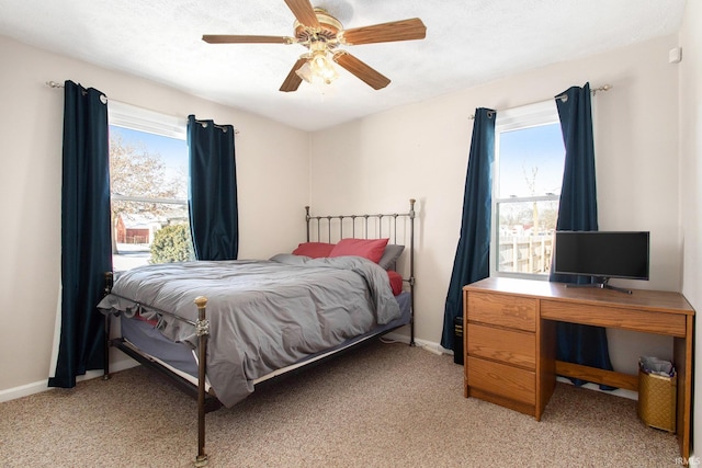 carpeted bedroom with ceiling fan and multiple windows